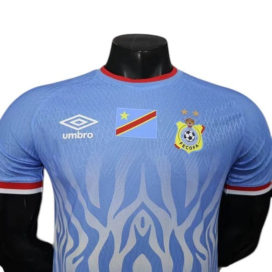 GOATkitz DR Congo 2026 player version home jersey in light blue with white tiger stripe pattern, red collar trim, and Umbro logo.