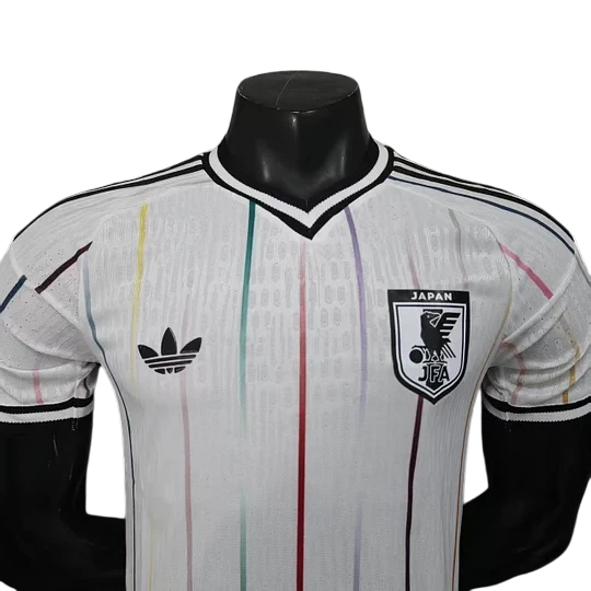 GOATkitz Japan 2026 player version away jersey in white with colourful vertical stripes and black trim. Features Adidas logo and Japan JFA crest.