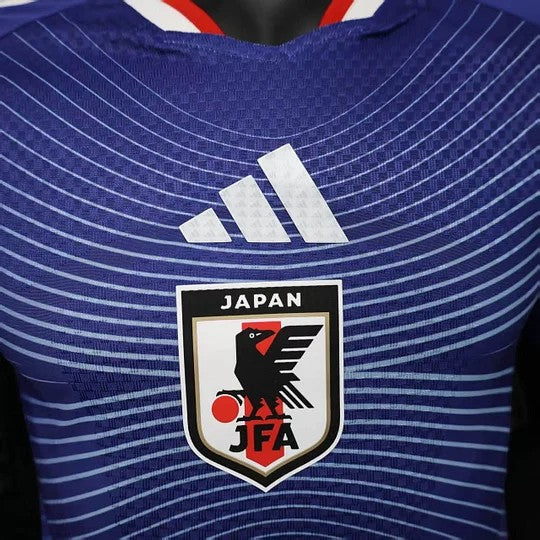 GOATkitz Japan 2026 player version home jersey in blue with white Adidas stripes and Japan Football Association crest.