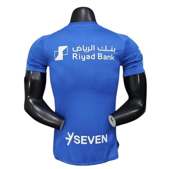 GOATkitz Al-Hilal 2025-26 player version home jersey in royal blue with white sponsor logos and "SEVEN" text.