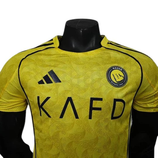 GOATkitz Al-Nassr 2025-26 player version home jersey in yellow with black accents and paisley pattern. Features Adidas logo and team crest.