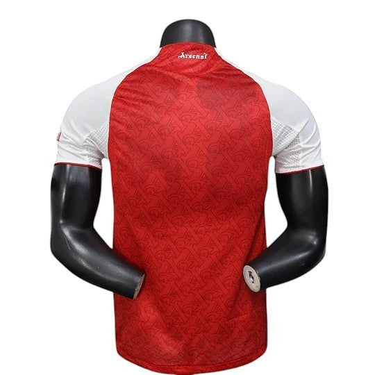 GOATkitz Arsenal 2025-26 Player Version Home Jersey, red with white sleeves and all-over Arsenal logo pattern.