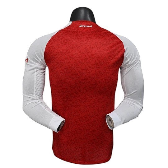 GOATkitz Arsenal 2025-26 Player Version Home long sleeve jersey in red with white sleeves and subtle Arsenal crest pattern.
