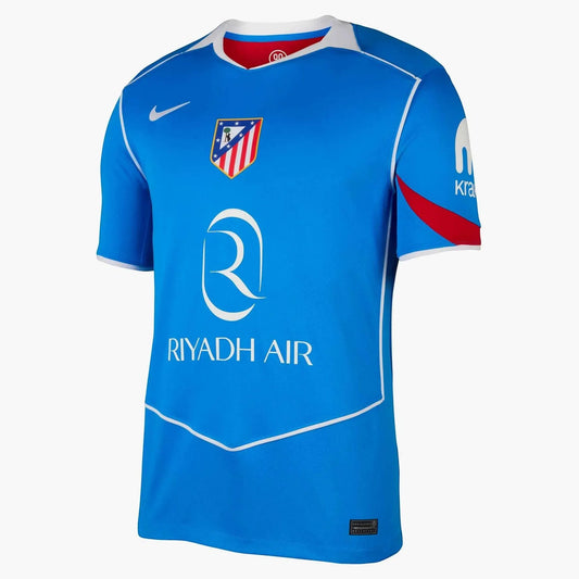 GOATkitz Atlético Madrid 2025-26 kids third jersey in blue with white trim and red accents on sleeves. Features club crest and Riyadh Air sponsor.