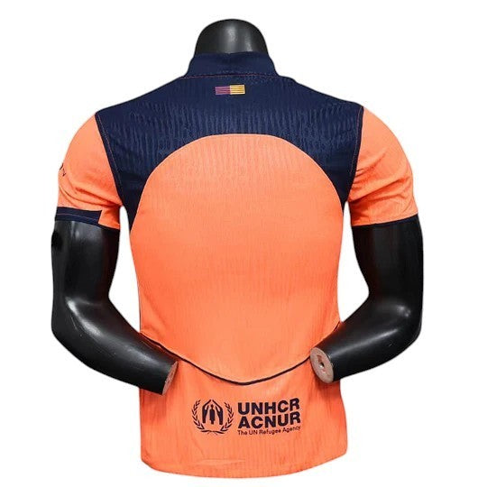 GOATkitz Barcelona 2025-26 adult player version third jersey in orange with navy blue accents and UNHCR logo.