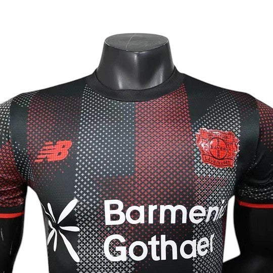 GOATkitz Bayer Leverkusen 2025-26 player version home jersey in black with red and white accents. Features sponsor logo and team crest.