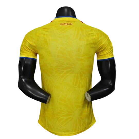 GOATkitz Colombia 2026 player version home jersey in yellow with blue trim on sleeves and collar. Features a subtle geometric pattern.