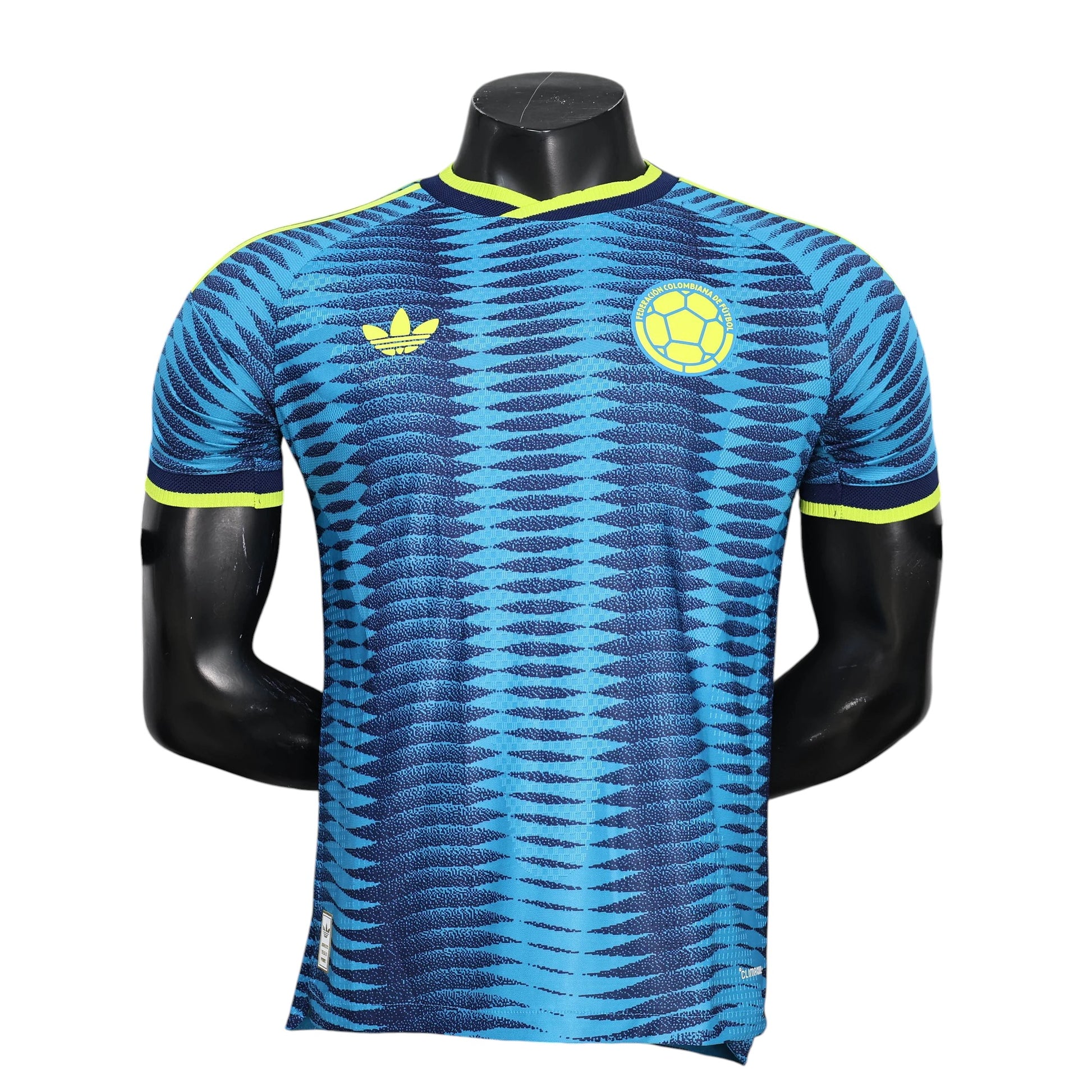 GOATkitz Colombia 2026 Player Version Away Jersey in blue with a geometric pattern and yellow accents. Features Adidas logo and Colombia crest.