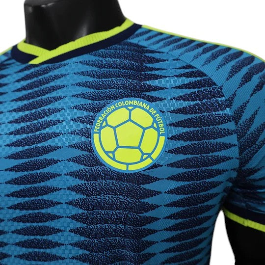 GOATkitz Colombia 2026 player version away jersey in blue with a graphic pattern and yellow crest. Features lime green trim on the collar.