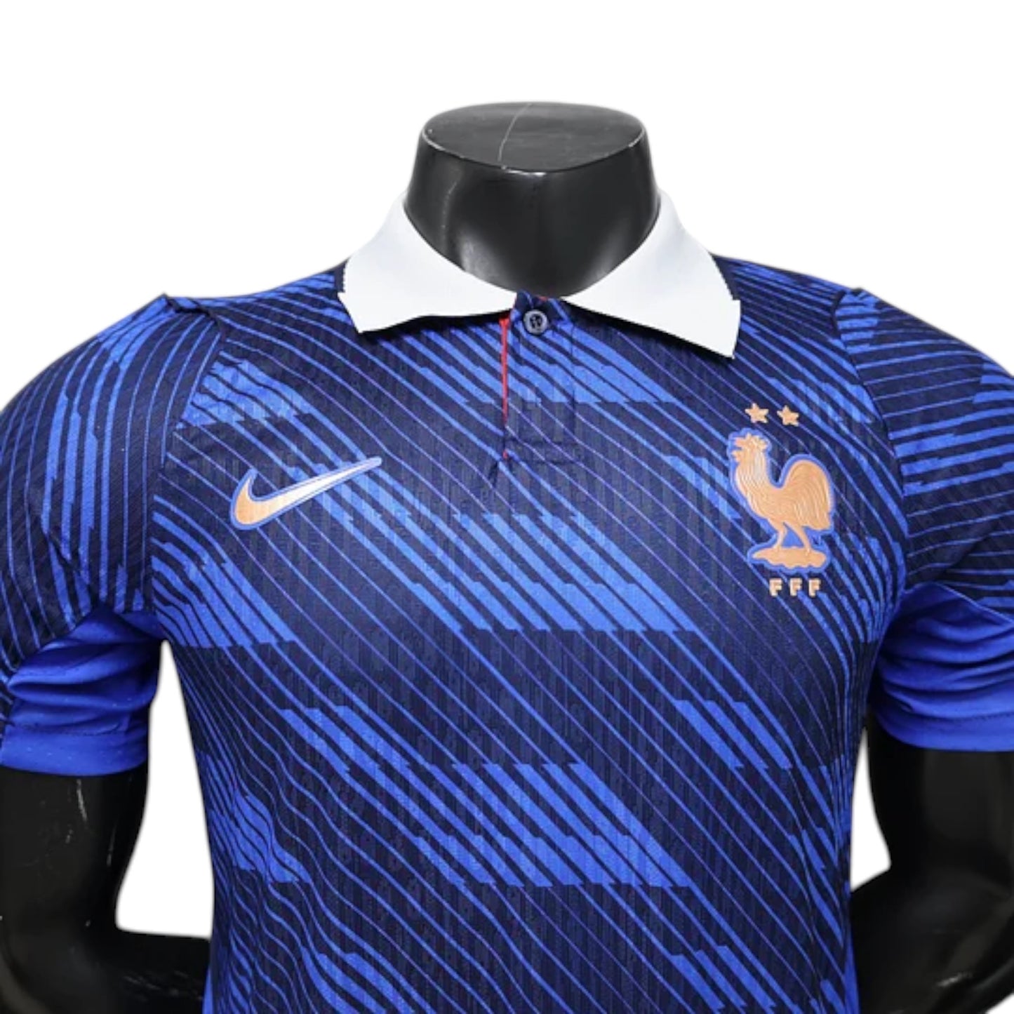 GOATkitz France 2026 player version home jersey in blue with a white collar and orange Nike logo. Features a graphic pattern and the French rooster crest.