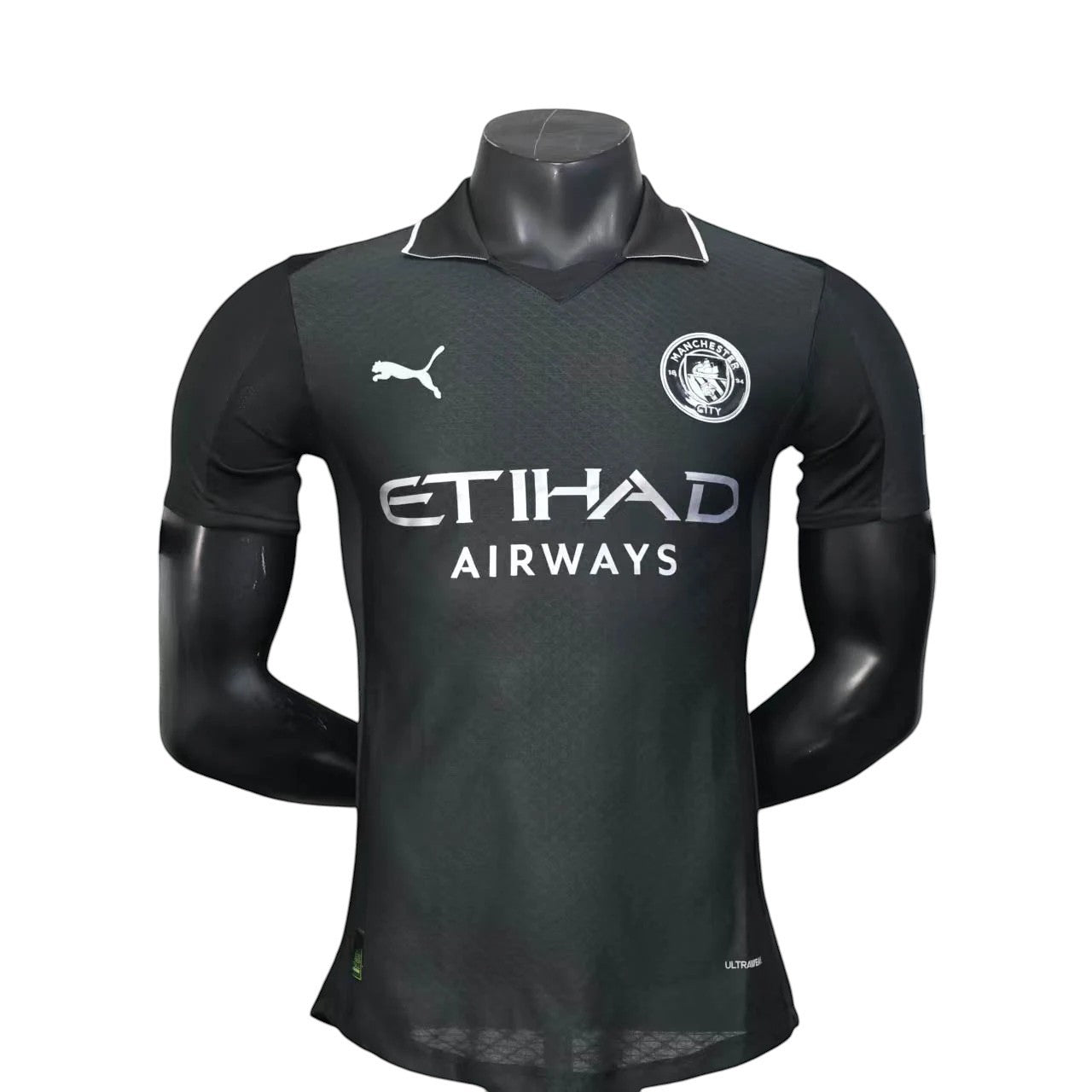 GOATkitz Manchester City 2025-26 adult player version away jersey in dark grey with white accents. Features Puma logo and Etihad Airways sponsor.