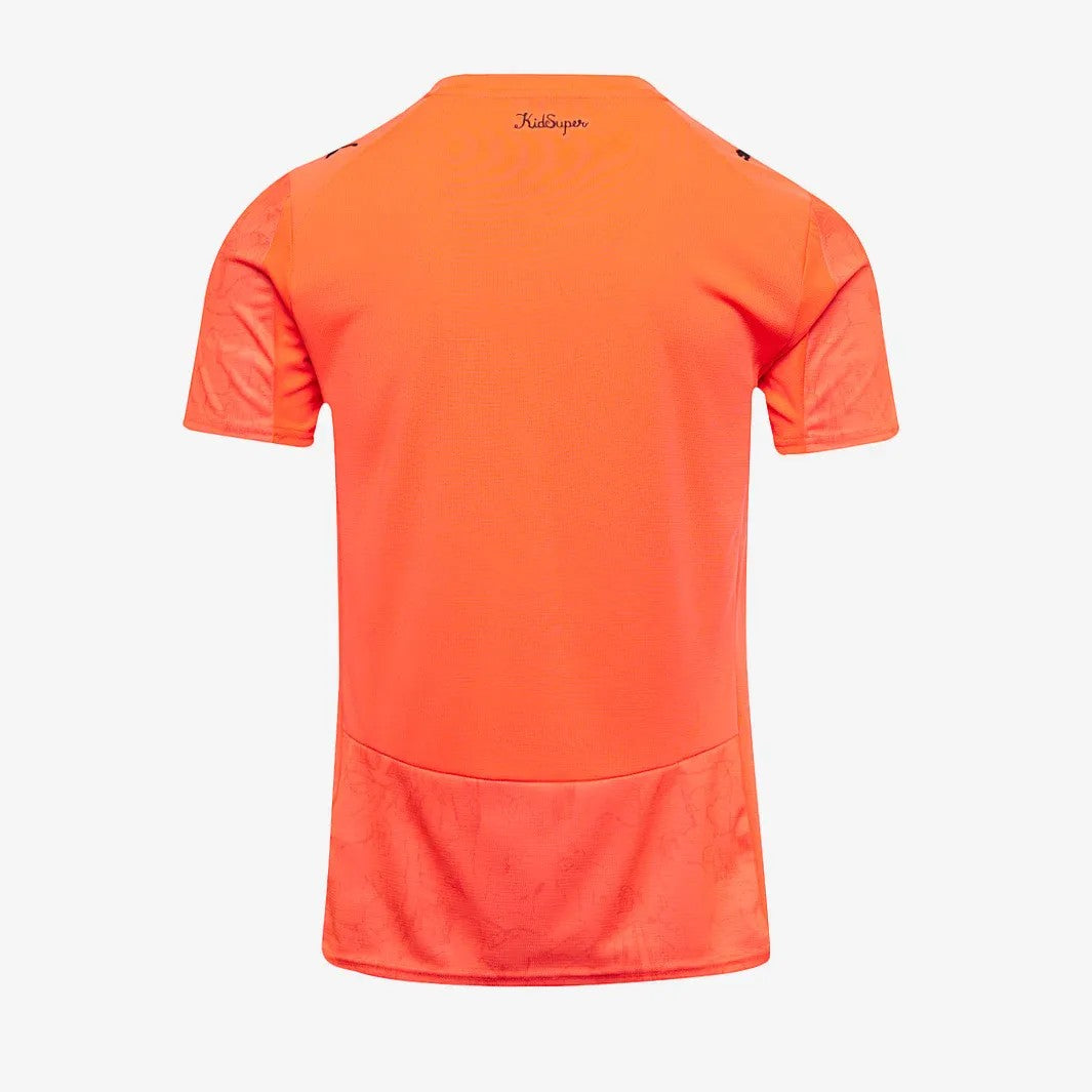 GOATkitz Manchester City x KidSuper orange kids jersey with subtle patterned panels on sleeves and hem.