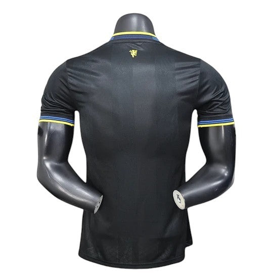 GOATkitz Manchester United 2025-26 black player version jersey with yellow and blue trim on collar and sleeves.