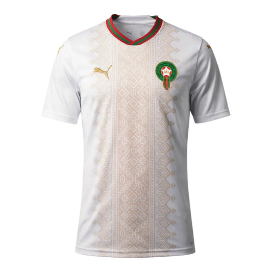 GOATkitz Morocco 2026 adult away jersey in white with gold Puma logo and Moroccan crest. Features a red and green striped collar and a beige geometric pattern down the front.