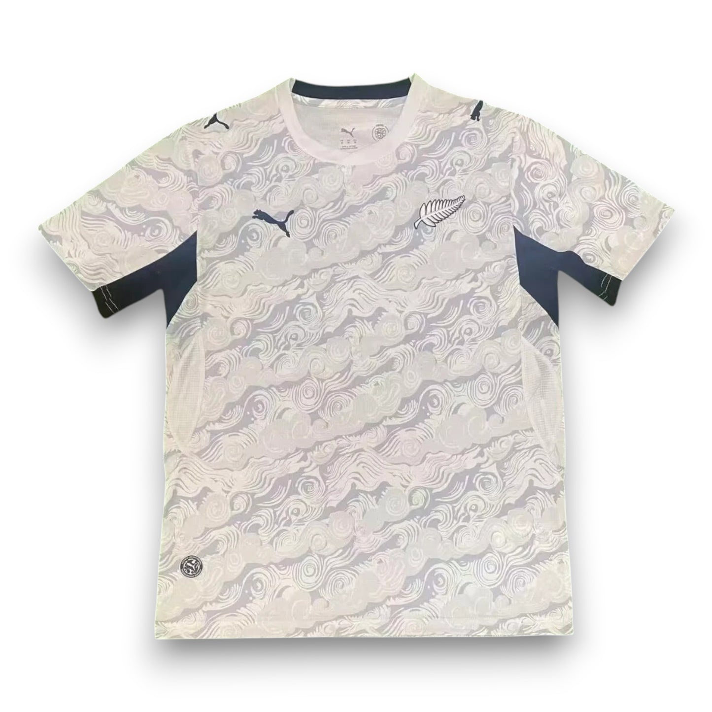 GOATkitz New Zealand 2026 adult home jersey, white with black accents and a swirling wave pattern. Features Puma logo and silver fern emblem.