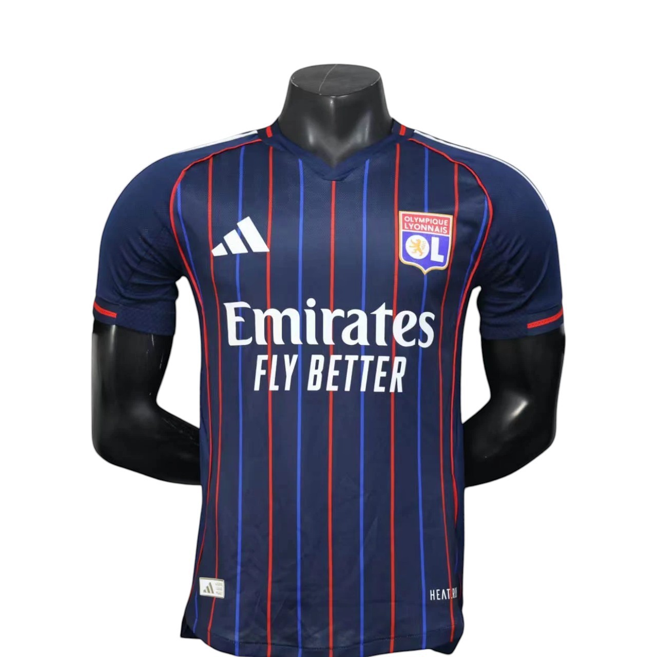 GOATkitz Olympique Lyonnais 2025-26 player version away jersey in navy with red and blue vertical stripes. Features Adidas logo and Emirates Fly Better sponsor.