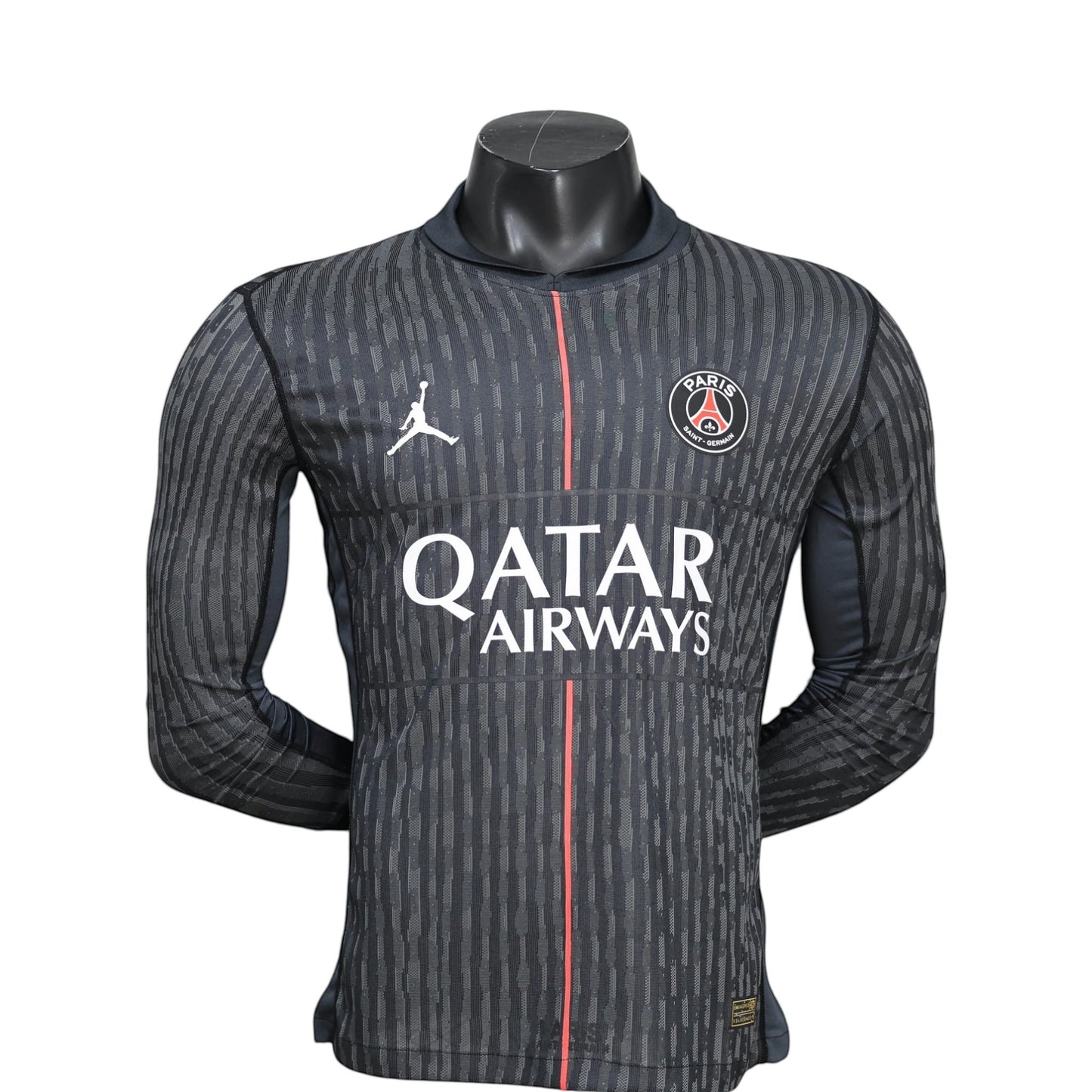 GOATkitz PSG 2025-26 Player Version Jordan long sleeve jersey in dark grey with vertical stripe pattern, red stripe detail, and Qatar Airways logo.