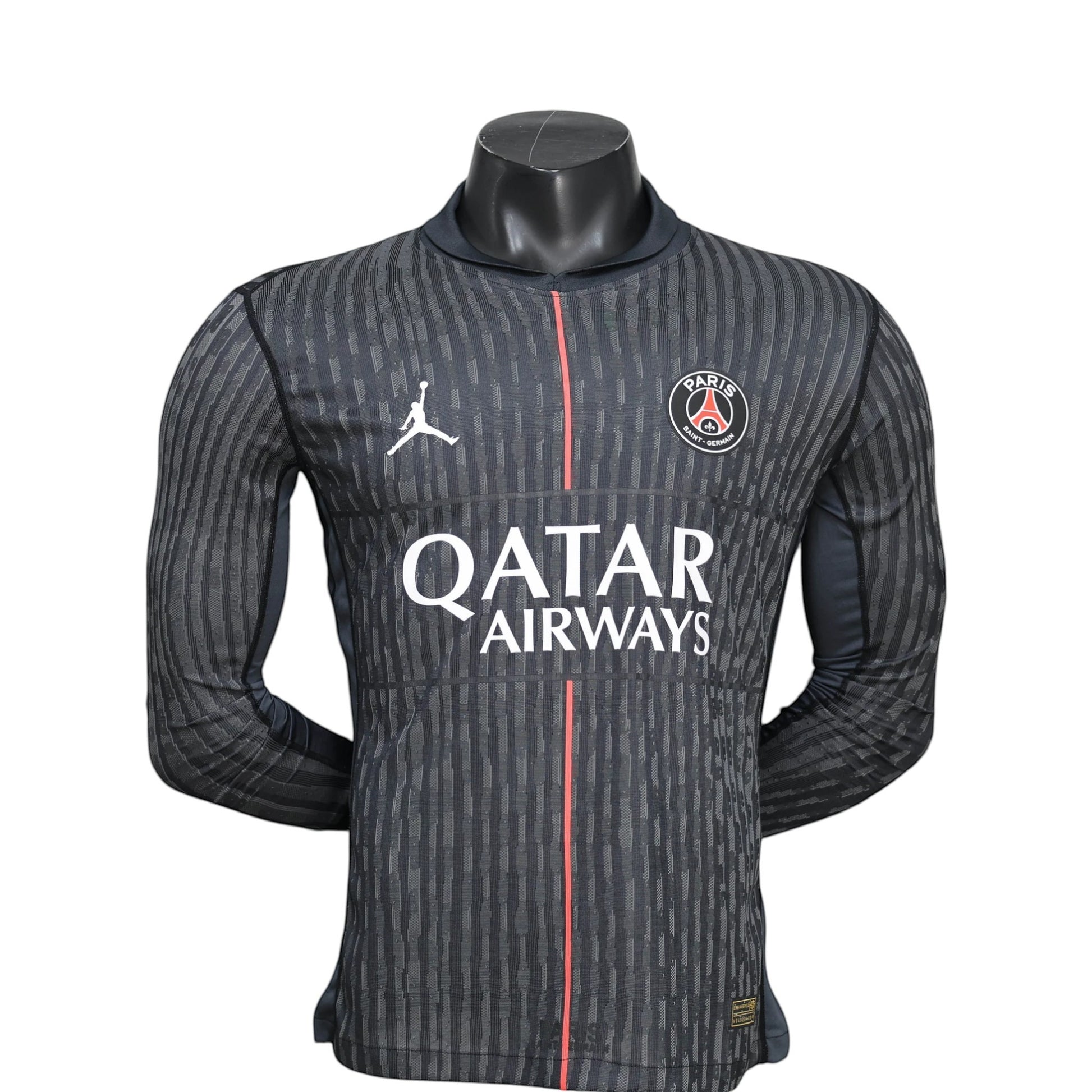 GOATkitz PSG 2025-26 Player Version Jordan long sleeve jersey in dark grey with vertical stripe pattern, red stripe detail, and Qatar Airways logo.