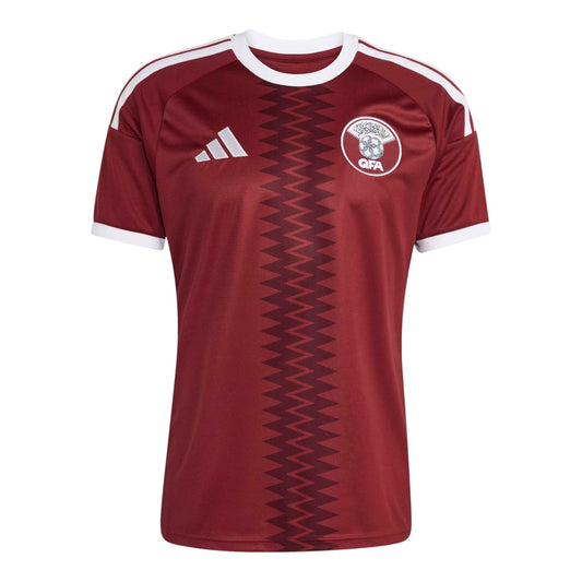 GOATkitz Qatar 2026 adult home jersey in maroon with white trim and zigzag pattern. Features QFA crest and Adidas logo.