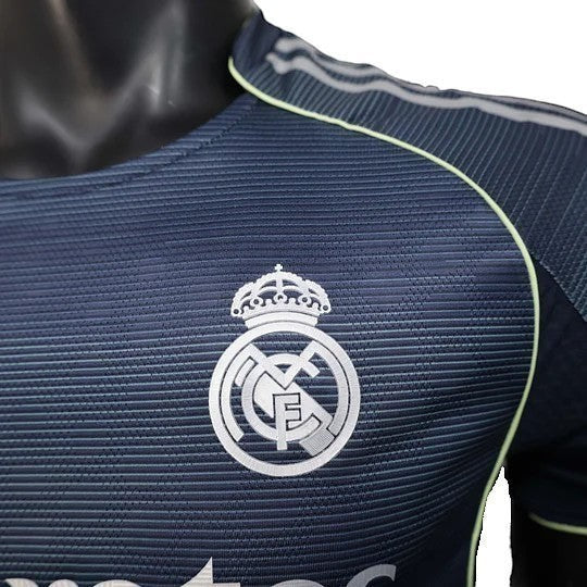 GOATkitz Real Madrid 2025-26 adult player version away jersey in navy blue with silver crest and lime green accents.