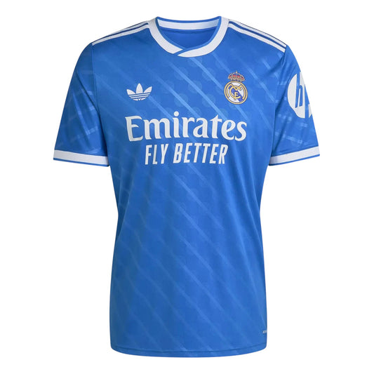 GOATkitz Real Madrid 2025-26 blue short-sleeve fan jersey with white trim, Emirates Fly Better sponsor, and Adidas logo.