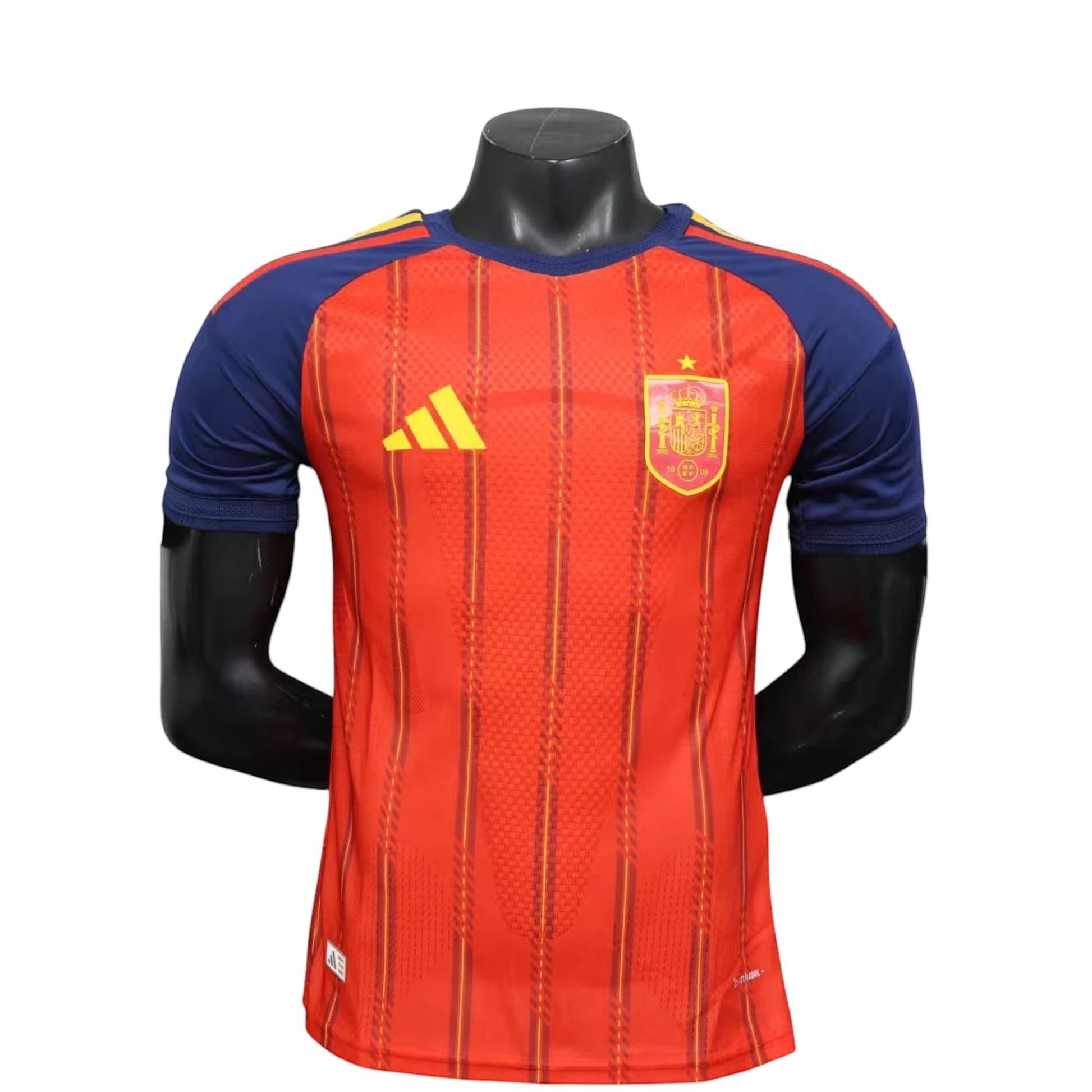 GOATkitz Spain 2026 player version home jersey in red with navy blue sleeves and yellow accents. Customizable.