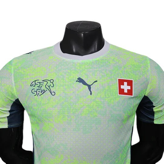 GOATkitz Switzerland 2026 player version away jersey in lime green with dark blue accents. Features Puma logo and Swiss Football Association crest.